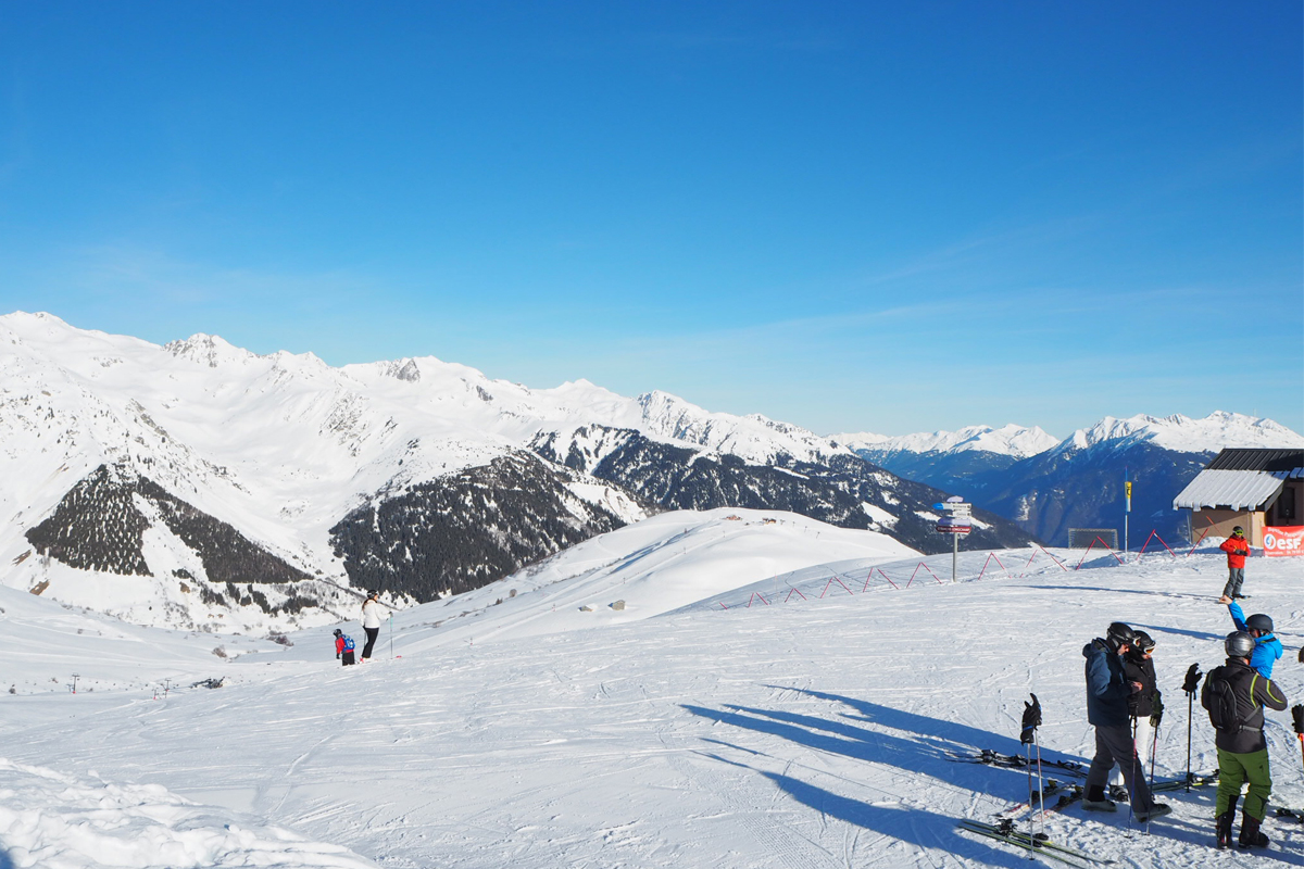 Family skiing in Valmorel: A view of the slopes on a clear blue day